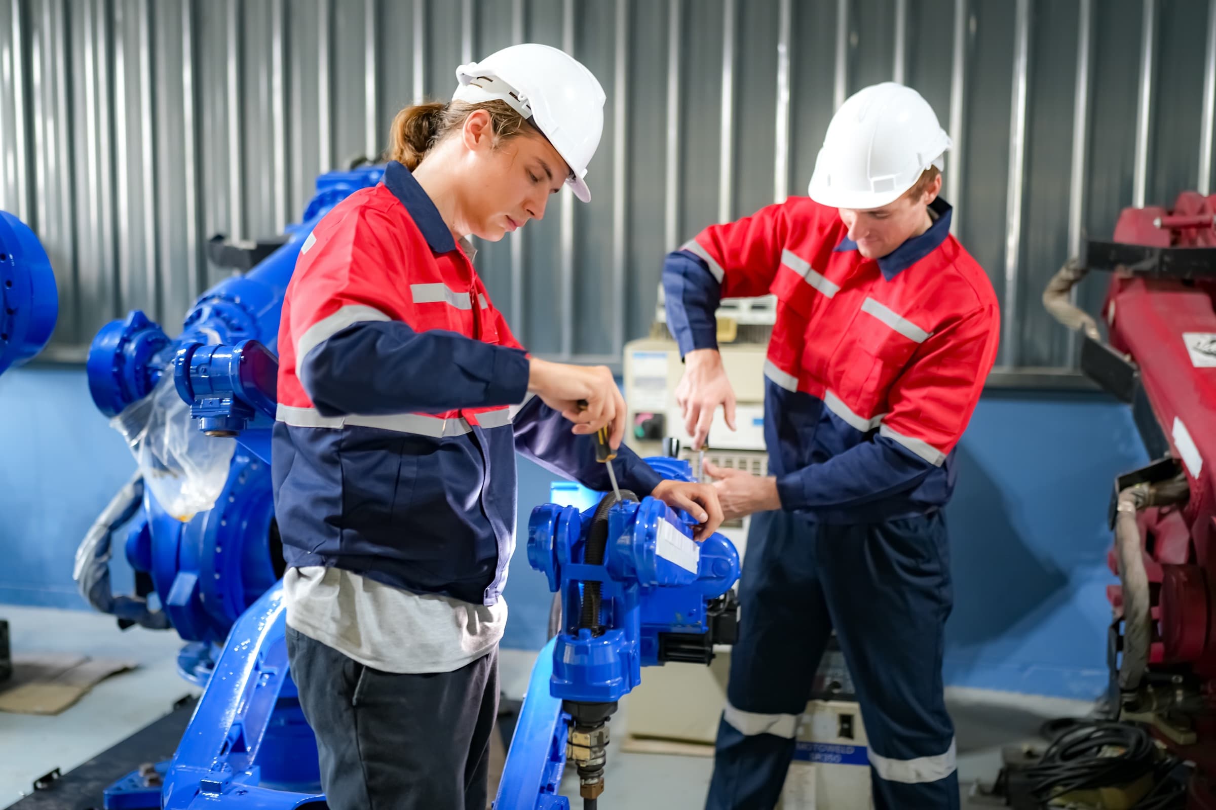 Two technicians working together on robotic equipment